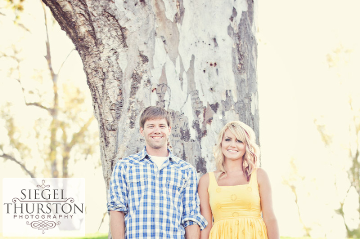 pam and jeremiah standing in front of a large eucalyptus tree at lake Poway in san diego