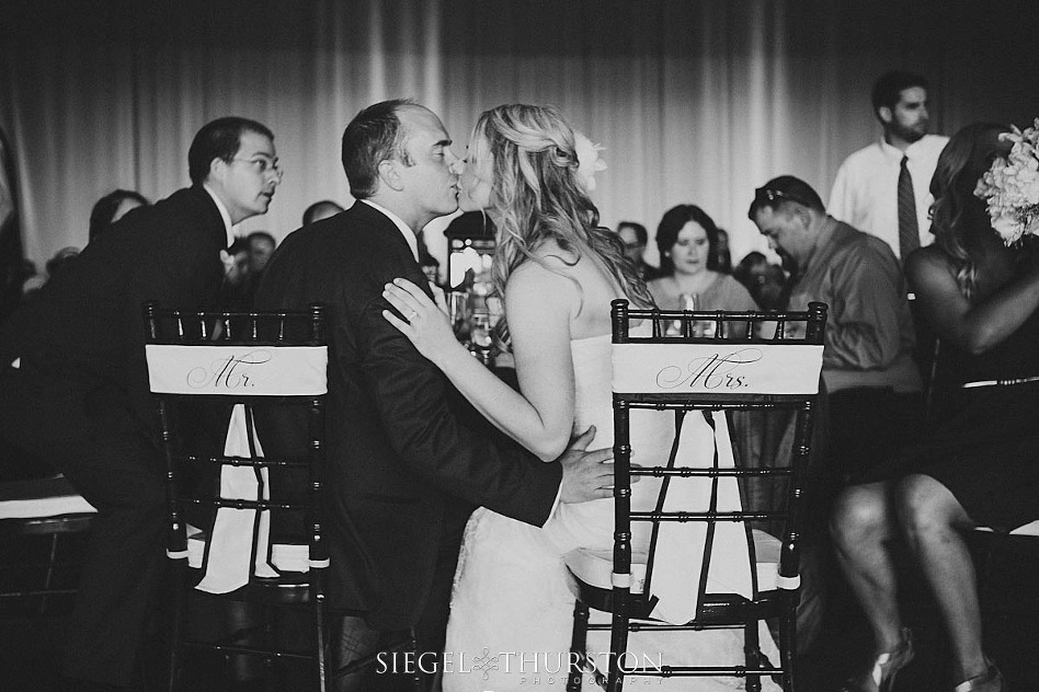 bride and groom kiss at the head table