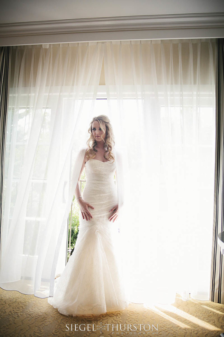 beautiful bride standing in the window at Estancia Hotel and Spa