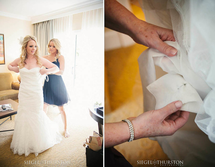 sister helping the bride get into her wedding dress