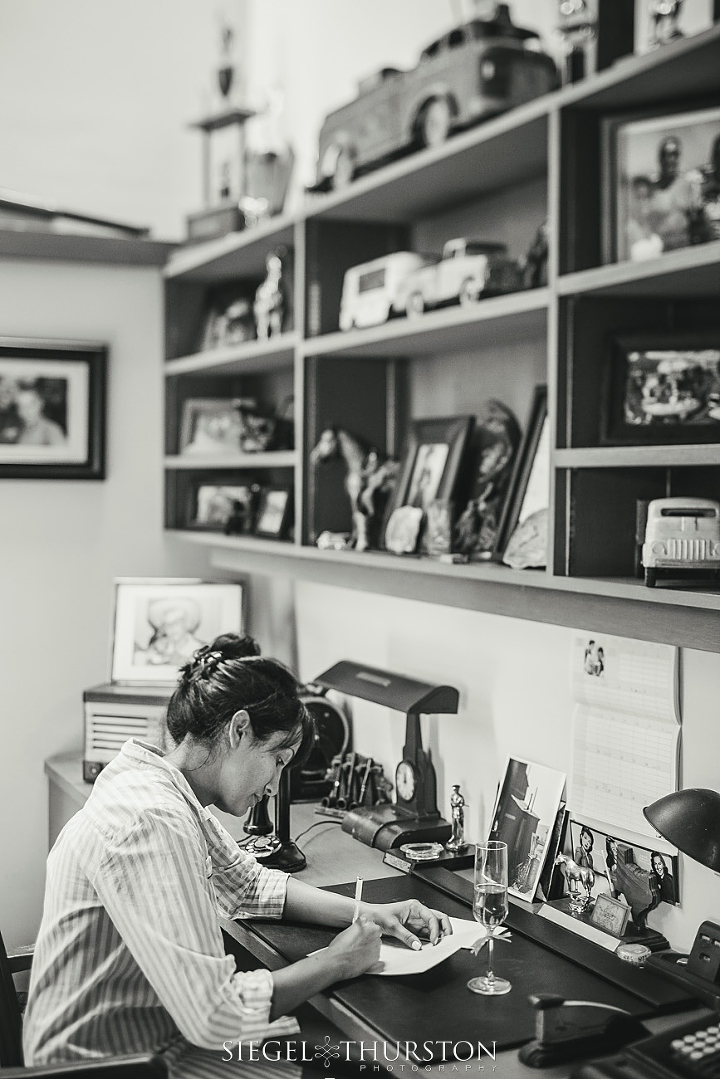 bride hand writing out her vows in the study