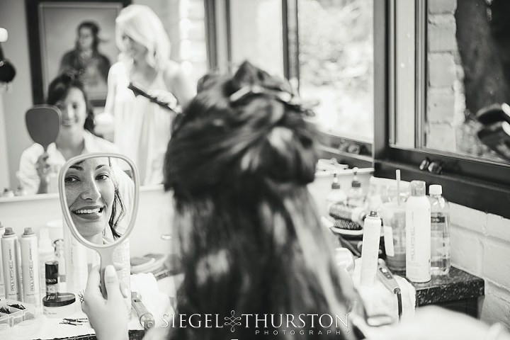 bride looking back at the camera in a vintage hand mirror