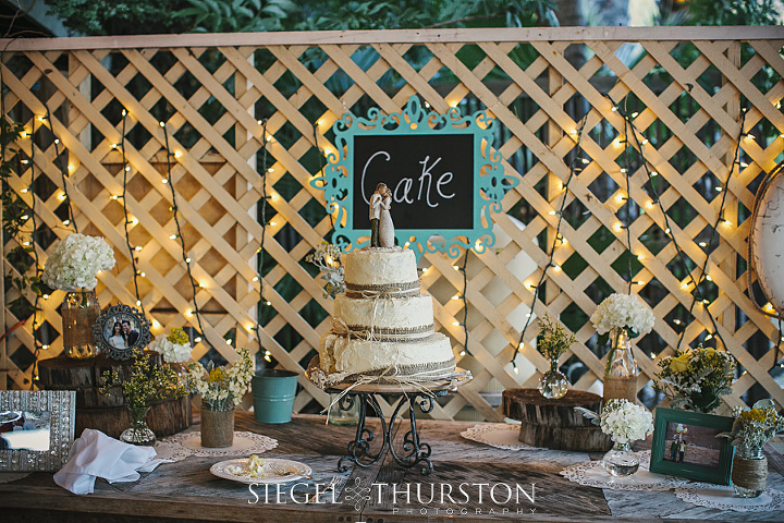 white wedding cake with burlap ribbon