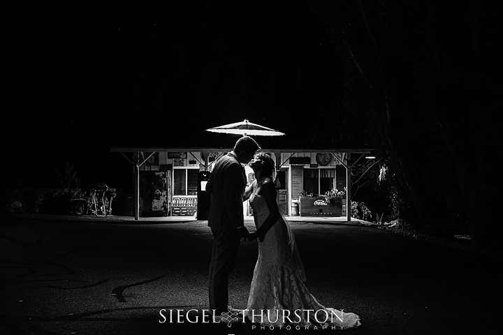 bride and groom at night light by an umbrella