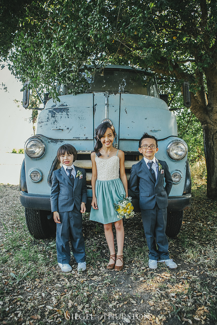 flower girl and ring bearers in front of an old vintage truck
