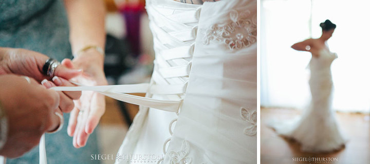 bride getting into her lace up back wedding dress