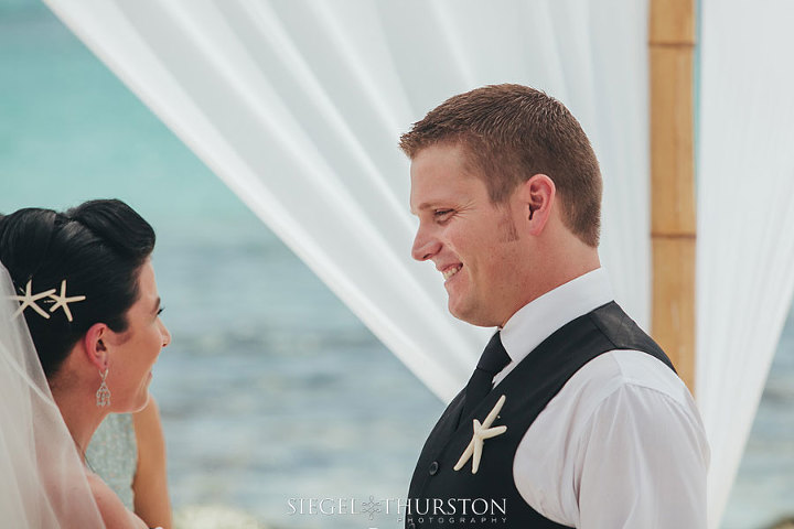 beach wedding emotional photo of the groom smiling at the ceremony