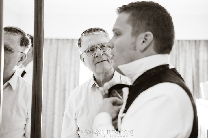 father watching his son get ready for his wedding