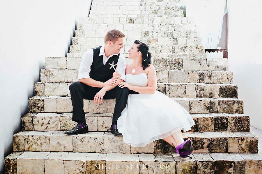 trash the dress playa del carmen evan and meagan sitting on stone steps in a cute authentic mexican village