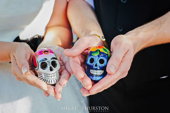 trash the dress in the town of playa del carmen in mexico bride and groom holding dia de los muertos skulls