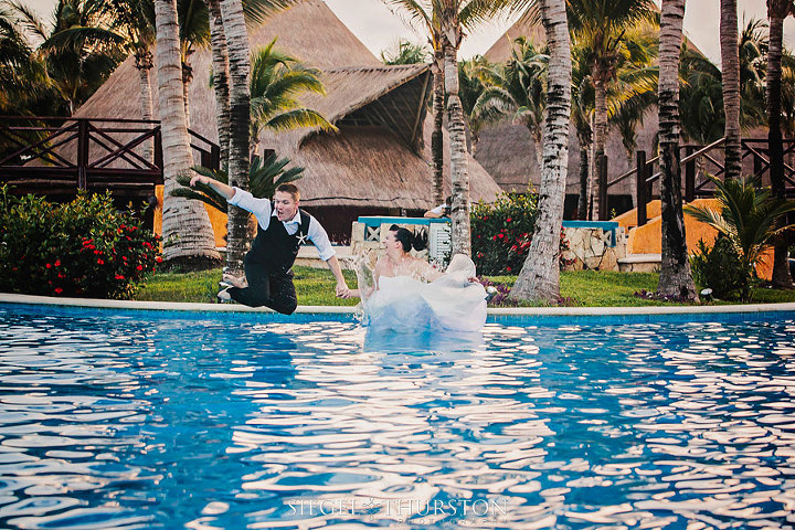 bride and groom making a splash into the pool at their tropical resort