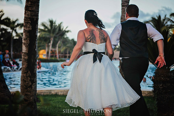 bride and groom getting ready to jump into the swimming pool
