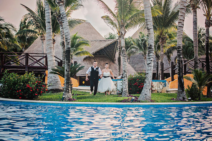 destination trash the dress where the bride and groom are getting ready to jump into the pool in their tux and wedding dress