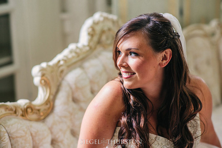 bride sitting on a beautiful vintage couch in the bridal suite at Green Gables Estates in San Diego