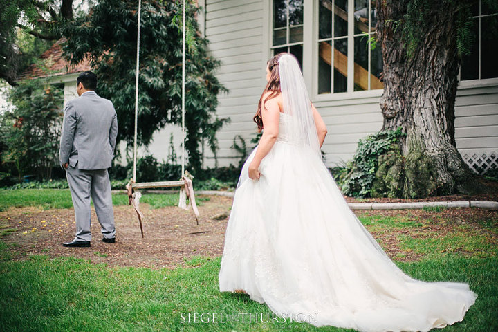 the bride and groom did a first look before their ceremony around the back of the old school house where the swing was.