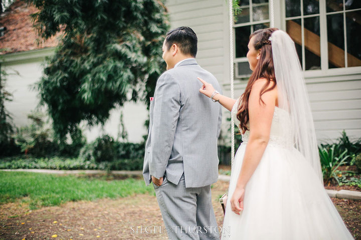 bride tapping the groom on the shoulder to turn around and see her for the first time.