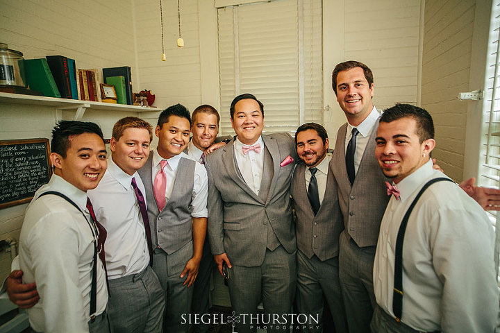 the groom and his groomsmen hanging out before the ceremony in the smallest grooms getting ready room ever