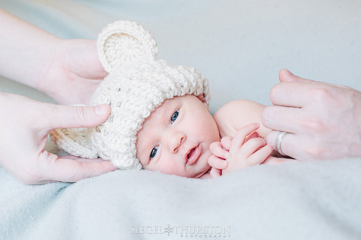 newborn baby wearing a cute knit bear hat