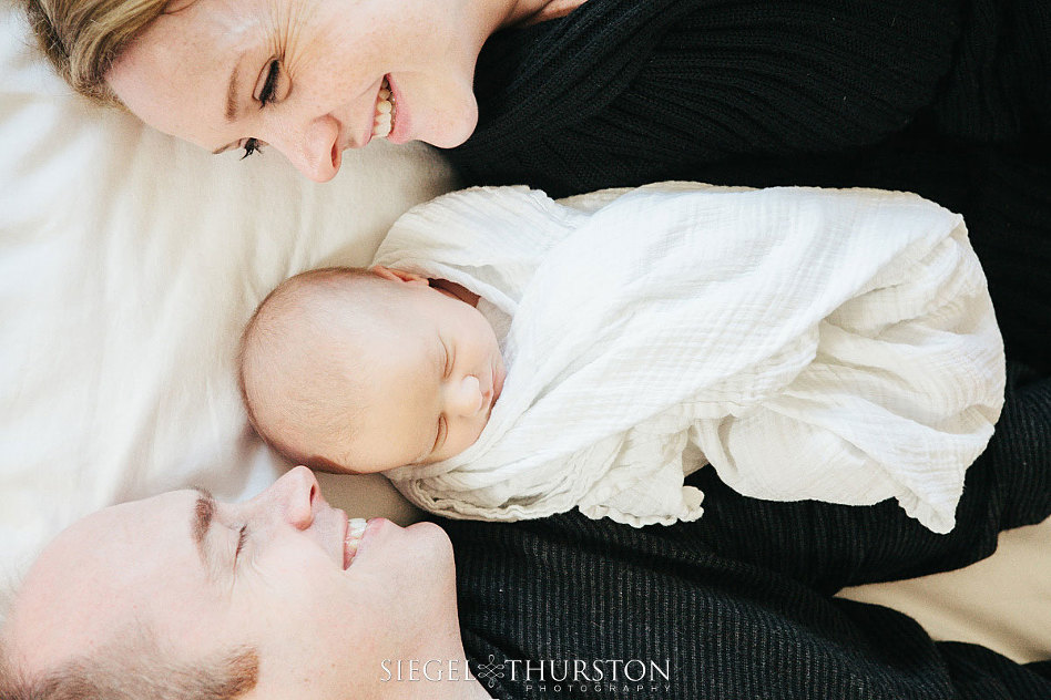 fun family portraits of new parents and their 2 week old baby