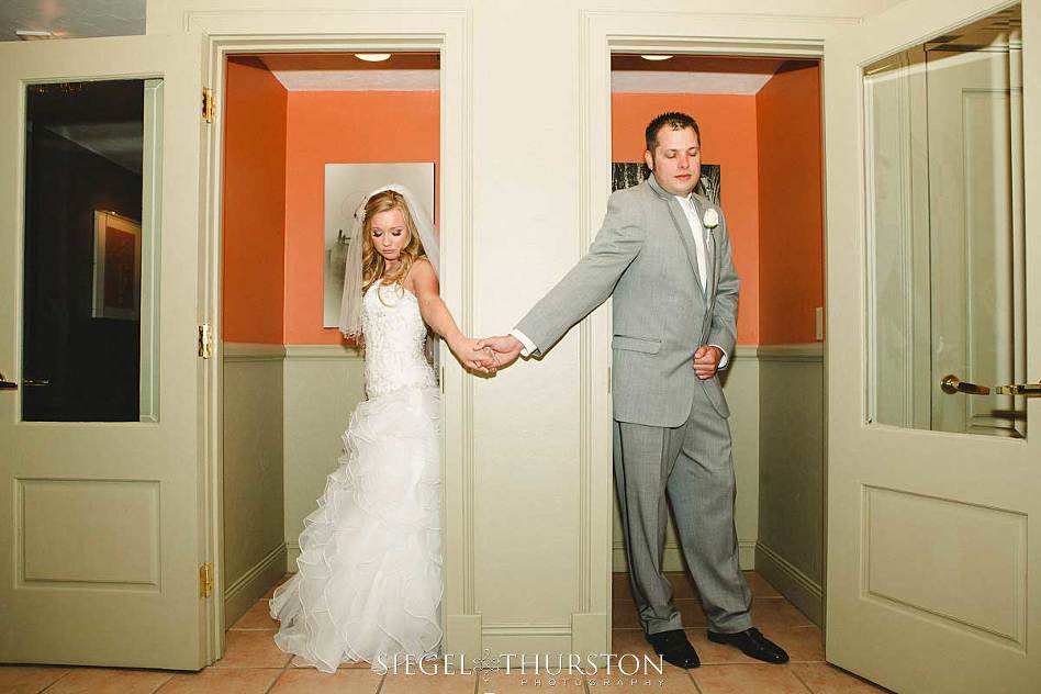 bride and groom having a pre wedding prayer from two phone booths so that they wont see one another before the ceremony