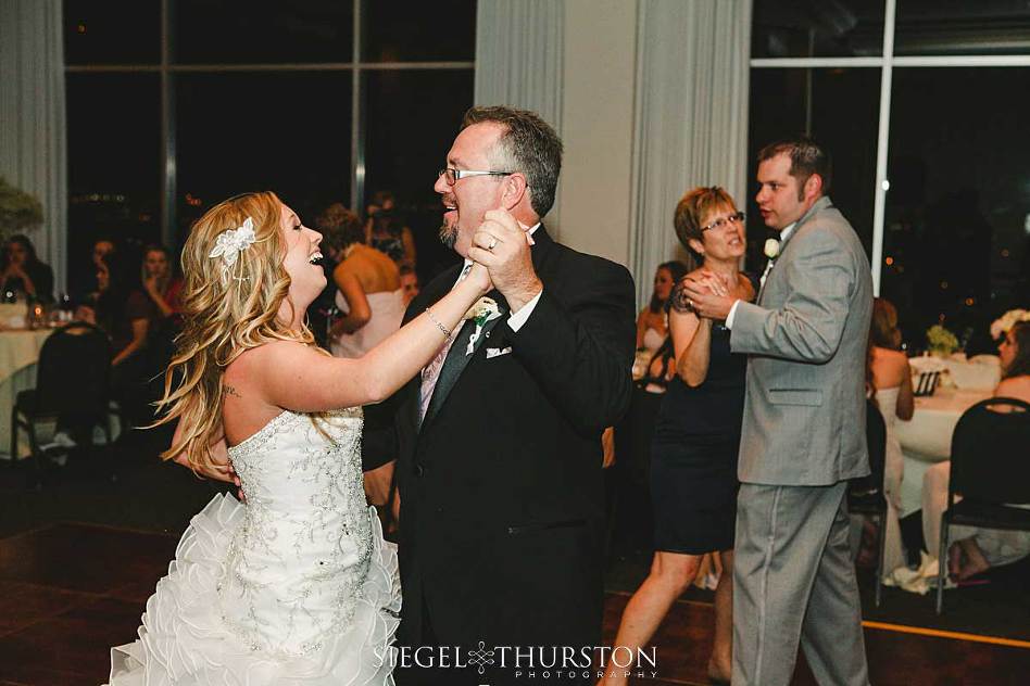 bride dancing with her dad at her wedding and laughing