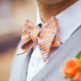 orange bow tie and gray mens sweater vest
