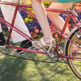 couple on a styled engagement shoot riding a tandem bicycle