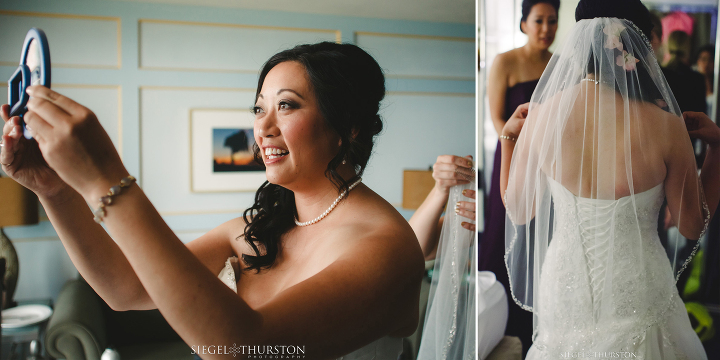 bride watching her bridesmaid put her veil in on a hand mirror