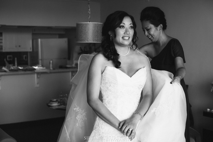 bridesmaid helping the bride with her wedding dress
