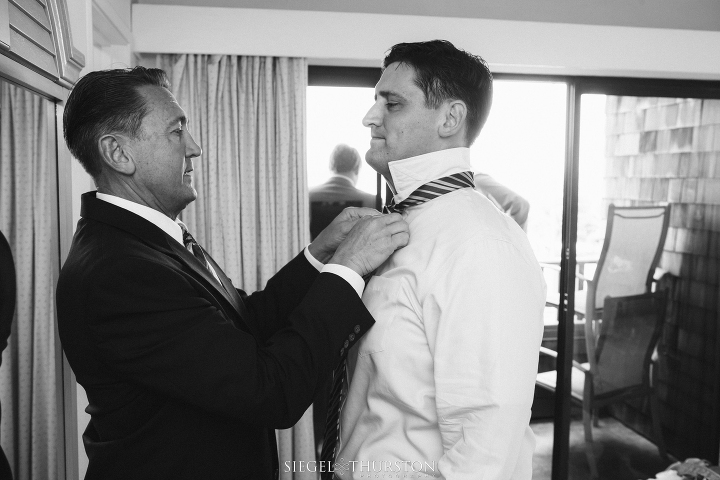 the grooms father helping him with his tie