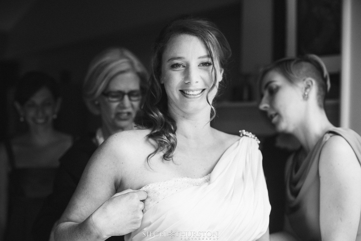 gorgeous bride getting into her wedding dress before her scripps la jolla wedding in california