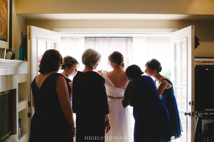 bridal party helping the bride into her wedding dress la jolla wedding