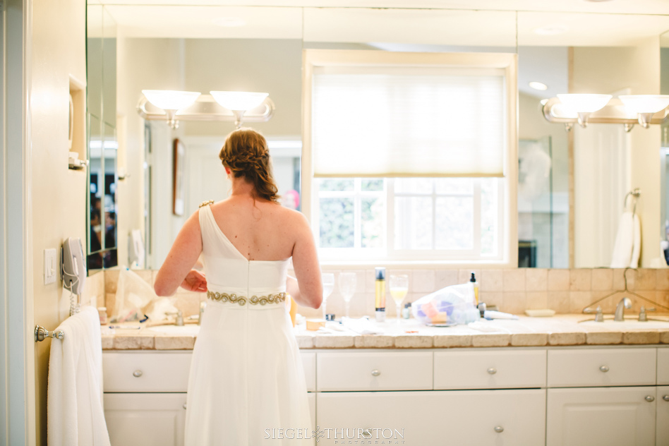 bride looking at her wedding dress in the mirror