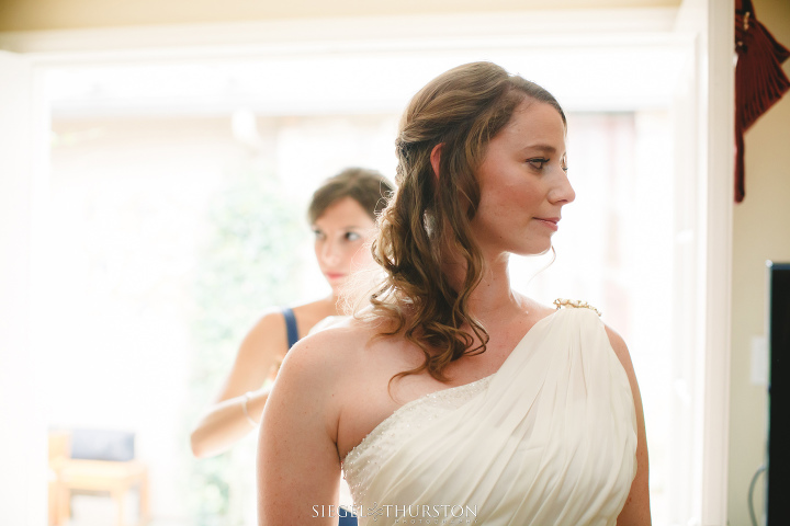 la jolla bride getting into her wedding dress