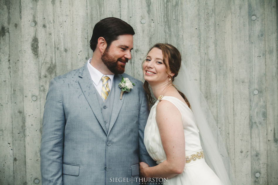 fun wedding portraits of groom in gray suite and bride in grecian style wedding dress