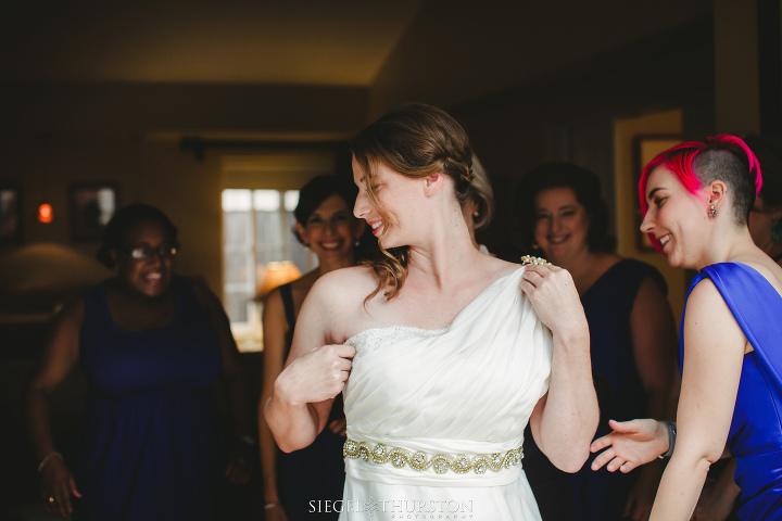 gorgeous bride getting into her wedding dress before her scripps la jolla wedding in california