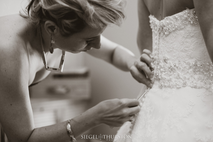 bride getting into her lace wedding dress before her Dallas Texas Wedding