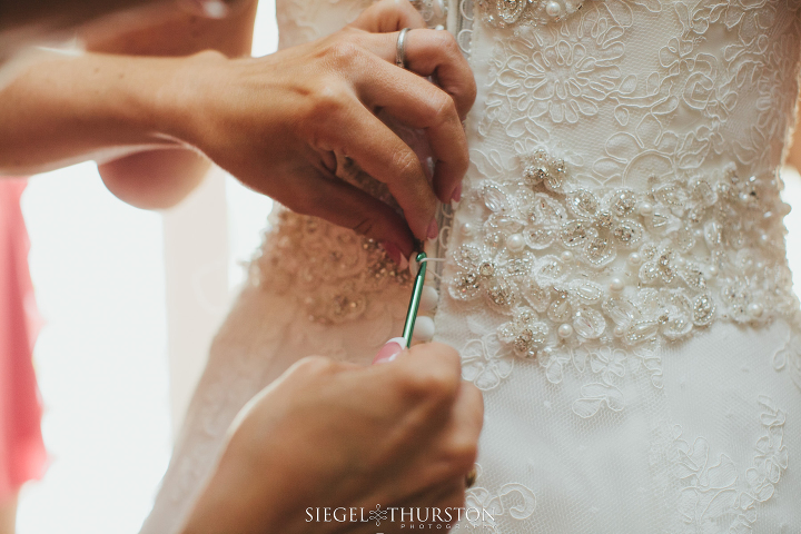 bride getting into her lace wedding dress before her Dallas Texas Wedding