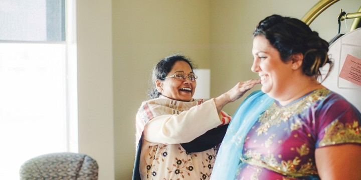 aunt helping the bridesmaids with their saris for Indian American wedding