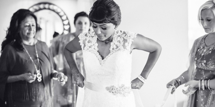 Bride putting on her lace keyhole wedding dress before her Indian American Wedding at The Dana Mission Bay