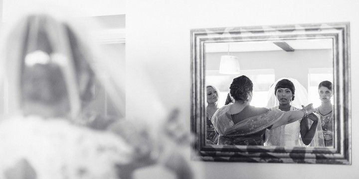 Bride putting on her lace keyhole wedding dress before her Indian American Wedding at The Dana Mission Bay