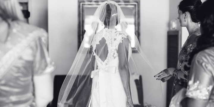 Bride putting on her lace keyhole wedding dress before her Indian American Wedding at The Dana Mission Bay