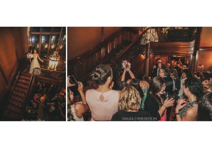 aldredge house wedding reception with the bride through her bouquet from the spiral staircase 