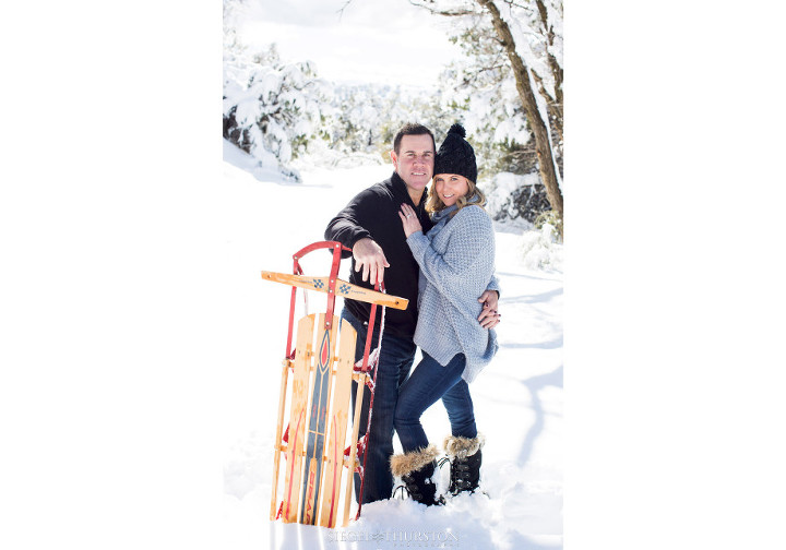 winter engagement shoot with a vintage sled
